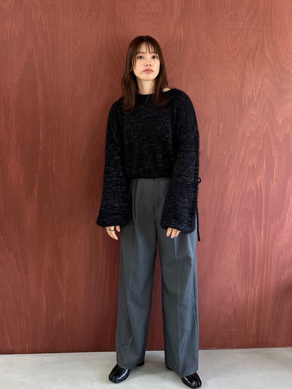 グリーン系のカーゴパンツ、ブラック系のニット/セーター、ブラック系のブーツを着用したレディースの秋コーディネートの2枚目の写真