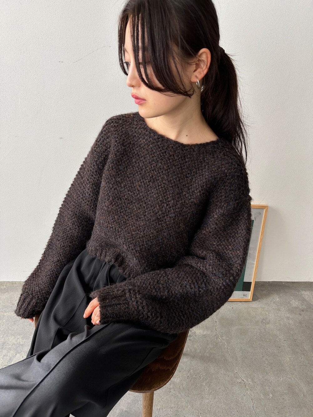 ブラウン系のニット/セーター、ブラック系のスラックス、ブラック系のスリッポンを着用したレディースの冬コーディネートの4枚目の写真