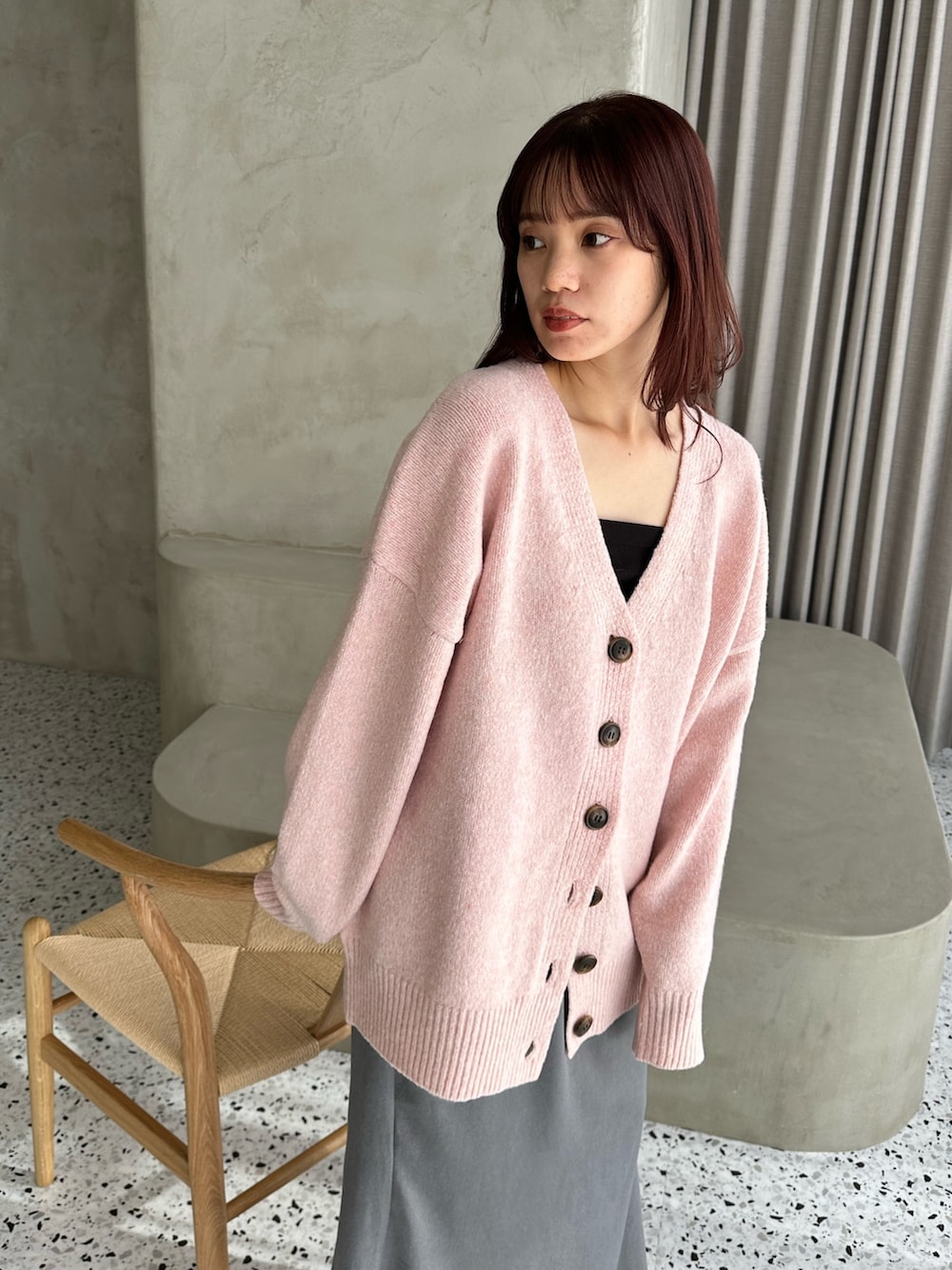 ピンク系のカーディガン/ボレロ、グレー系のスカート、ホワイト系のスニーカーを着用したレディースの冬コーディネートの3枚目の写真