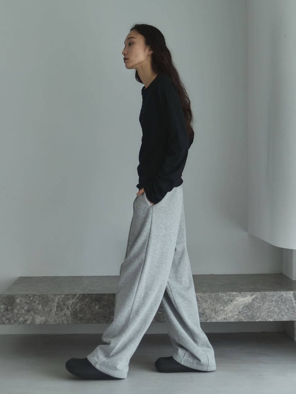 ブラック系のTシャツ/カットソー、グレー系のスウェットパンツ、ブラック系のサンダルを着用したレディースの秋コーディネートの2枚目の写真