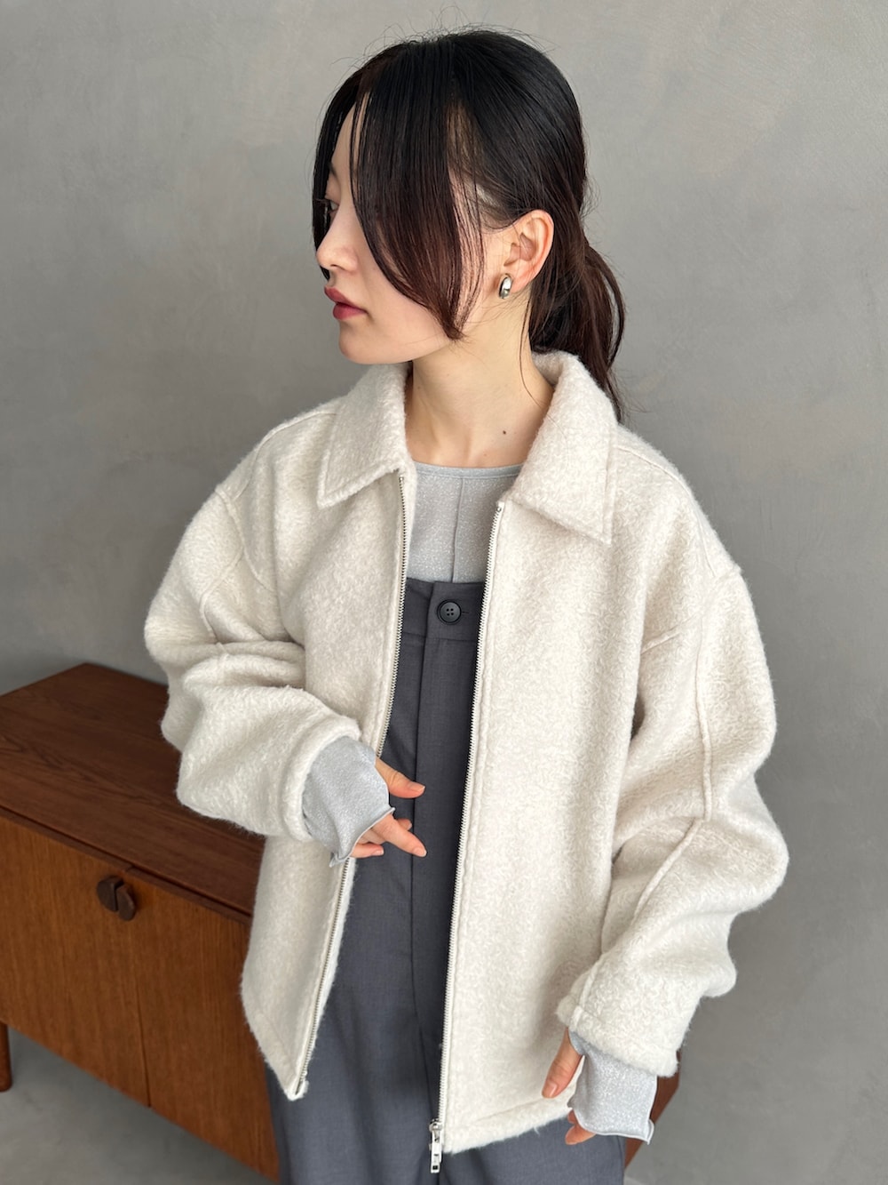 ホワイト系のブルゾン、シルバー系のTシャツ/カットソー、グレー系のサロペット/オーバーオールを着用したレディースの秋コーディネートの4枚目の写真