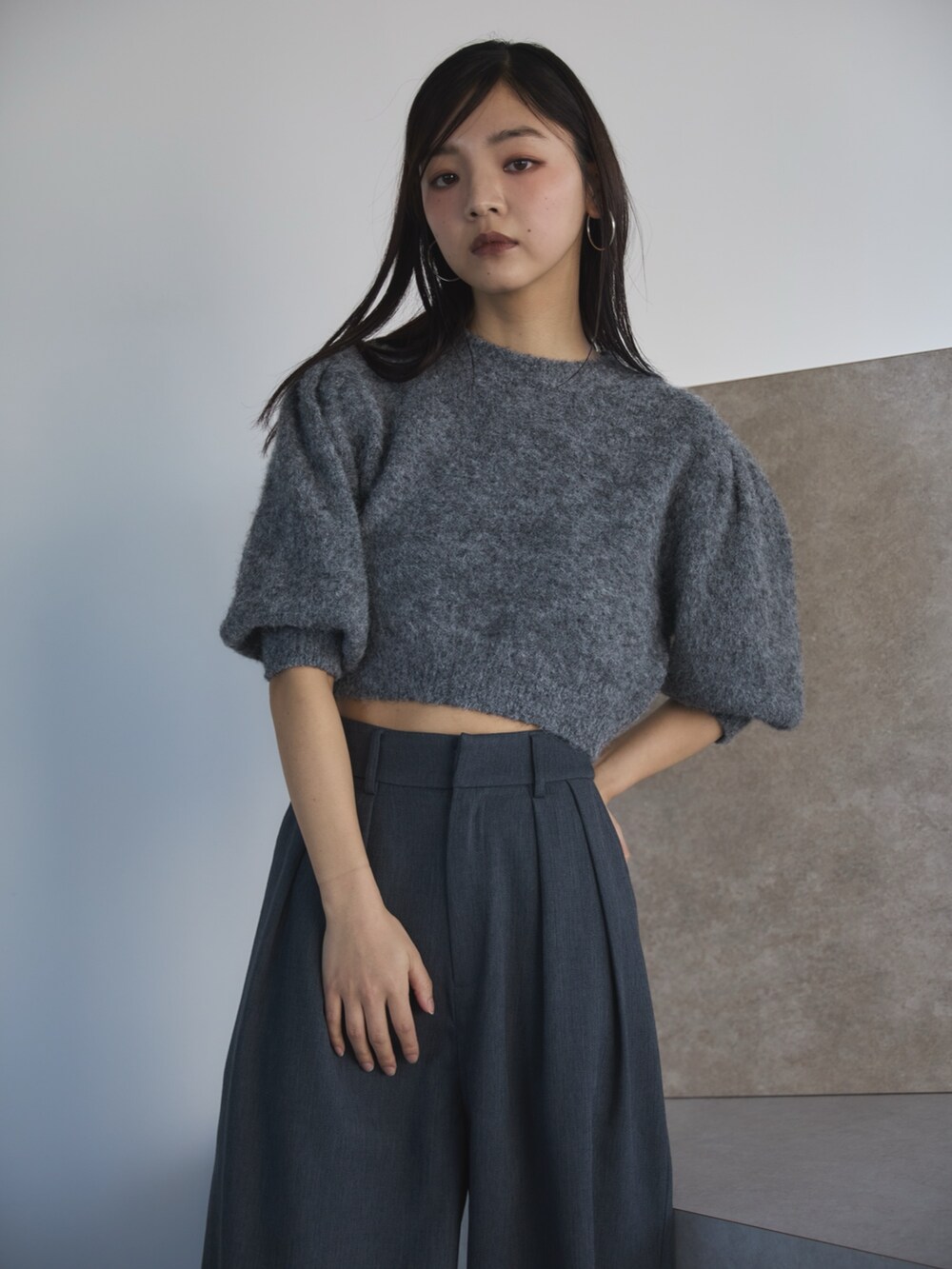 グレー系のニット/セーター、グレー系のスラックス、ブラック系のローファーを着用したレディースの冬コーディネートの4枚目の写真