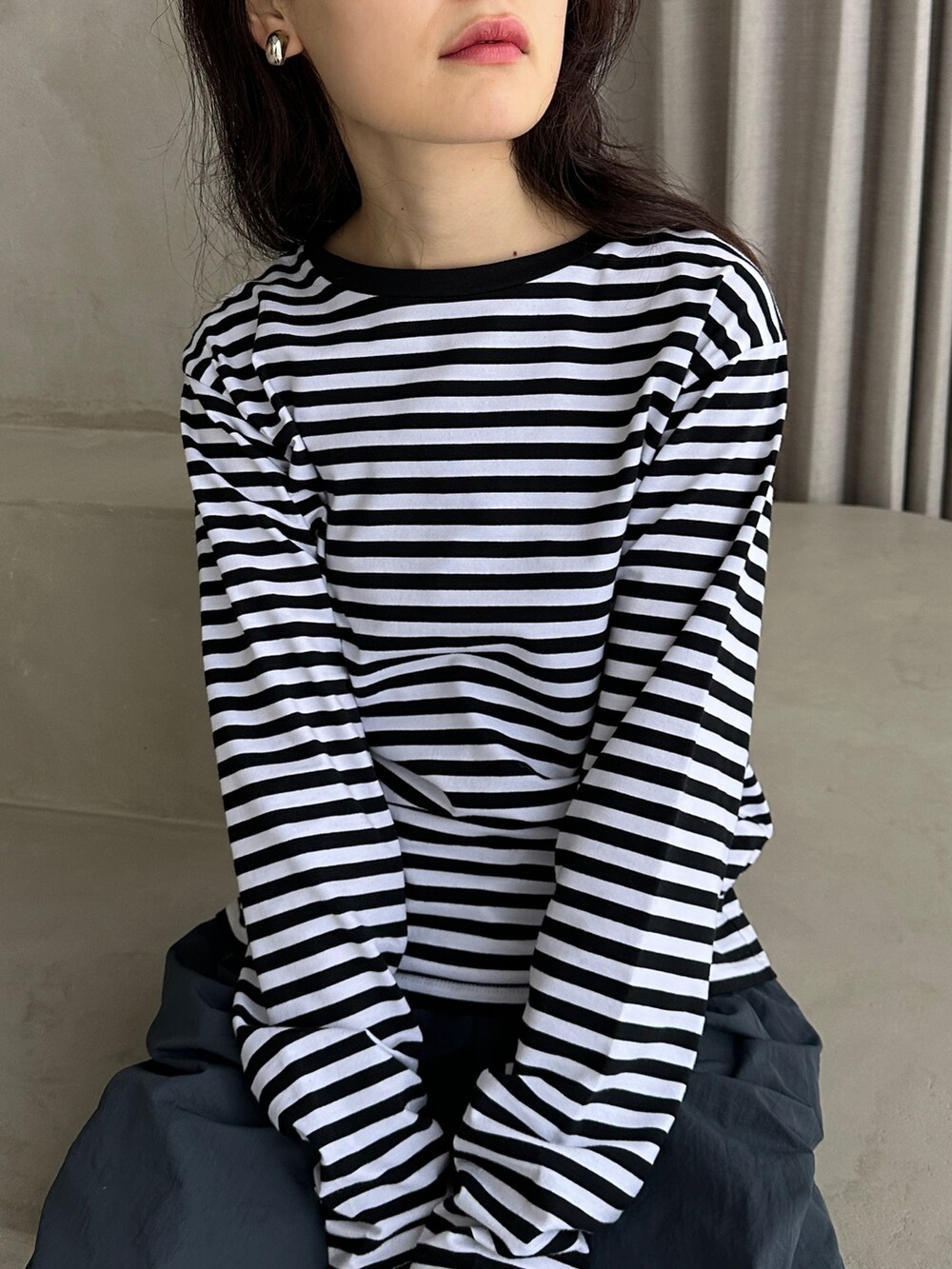 ブルー系のその他パンツ、ブラック系のダウンベスト、ブラック系のTシャツ/カットソーを着用したレディースの冬コーディネートの4枚目の写真
