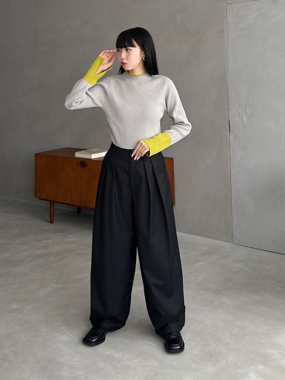 グレー系のニット/セーター、ブラック系のパンツを着用したレディースの秋コーディネートの2枚目の写真