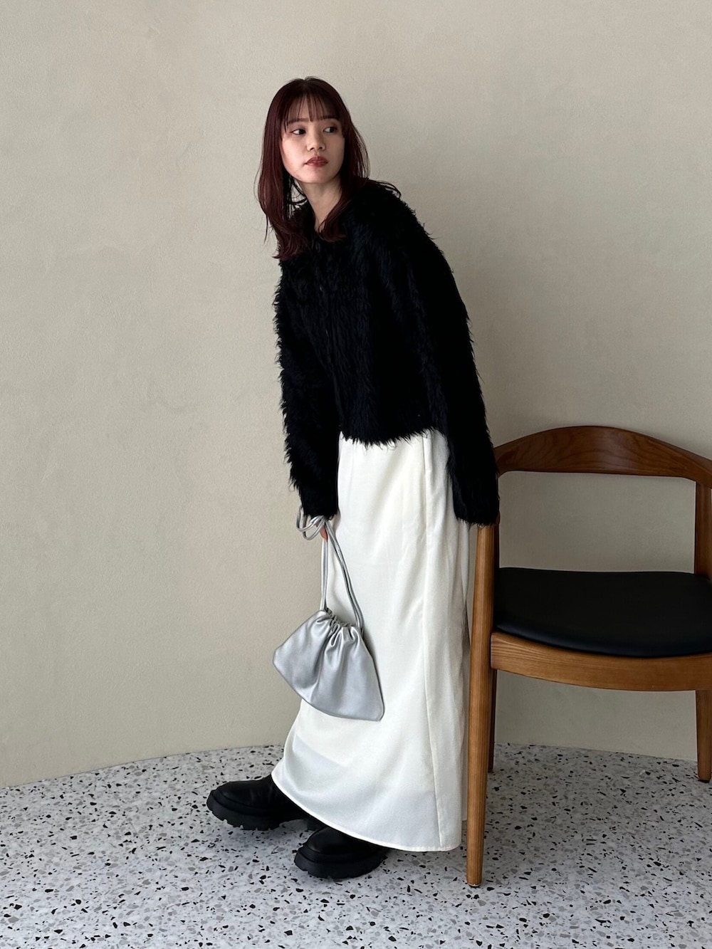 ブラック系のカーディガン/ボレロ、ホワイト系のスカート、シルバー系のショルダーバッグを着用したレディースの冬コーディネートの2枚目の写真