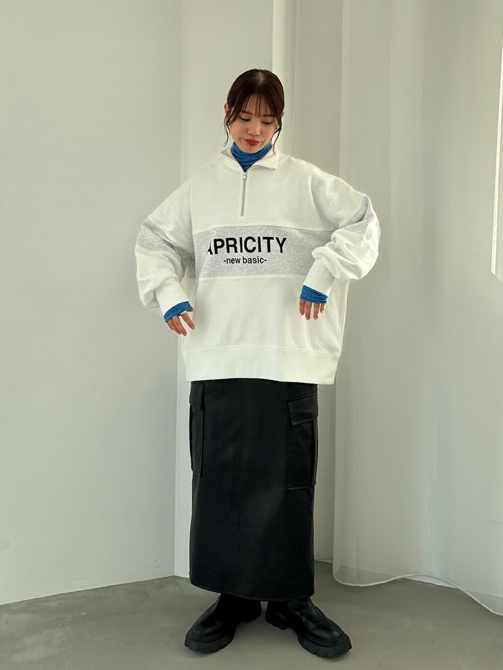 ホワイト系のスウェット、ブラック系のスカート、ブルー系のTシャツ/カットソーを着用したレディースの秋コーディネートの3枚目の写真