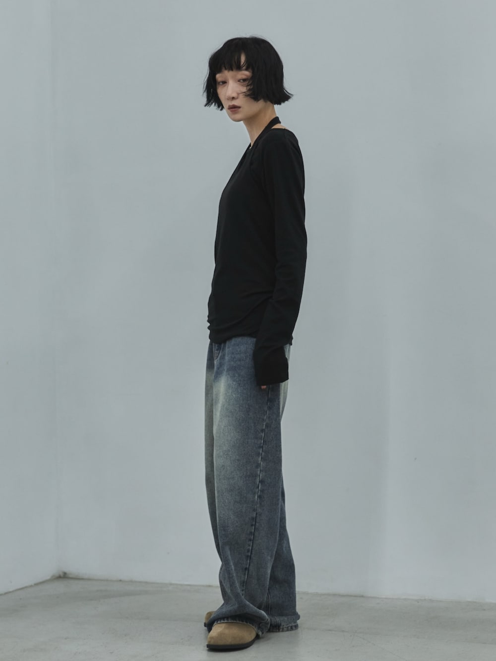 ブラック系のTシャツ/カットソー、ブルー系のデニムパンツ、ベージュ系のその他シューズを着用したレディースの秋コーディネートの2枚目の写真