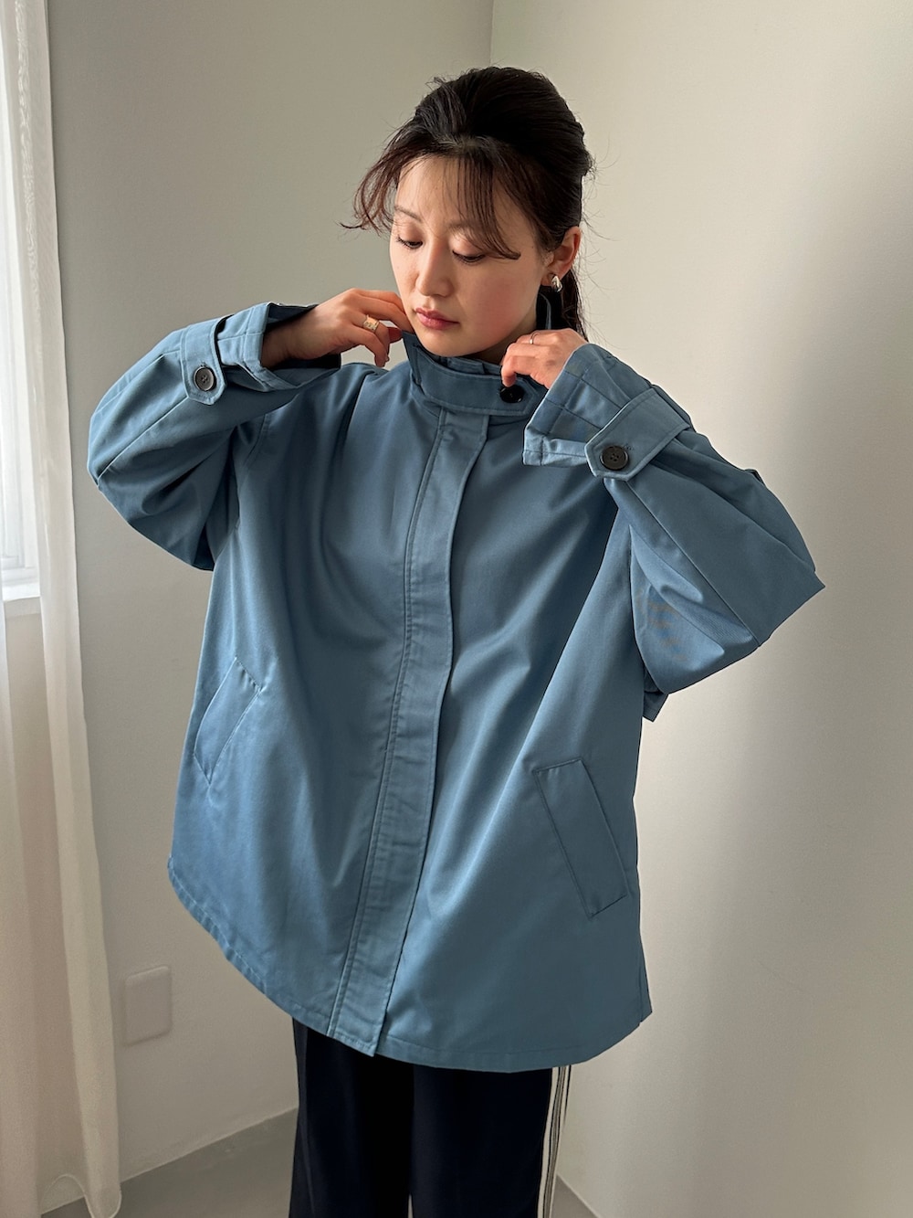 ブルー系のスラックス、ブラック系のスニーカー、ベージュ系のTシャツ/カットソーを着用したレディースの冬コーディネートの3枚目の写真