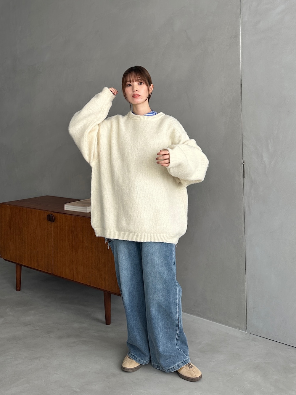 ホワイト系のニット/セーター、ブルー系のシャツ/ブラウス、ブルー系のデニムパンツを着用したレディースの冬コーディネートの2枚目の写真