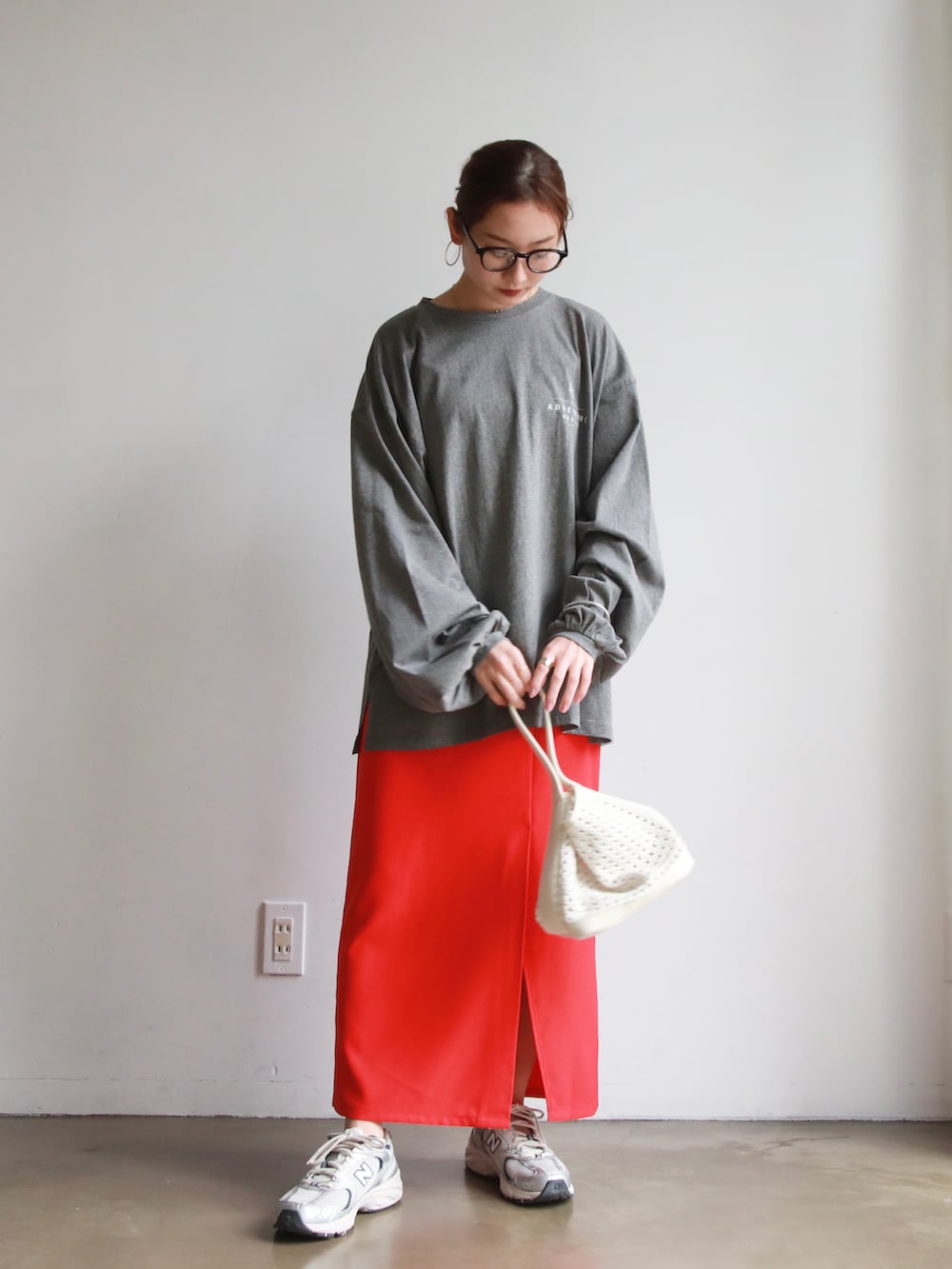 グレー系のTシャツ/カットソー、ホワイト系のトートバッグ、レッド系のスカートを着用したレディースの春コーディネートの2枚目の写真