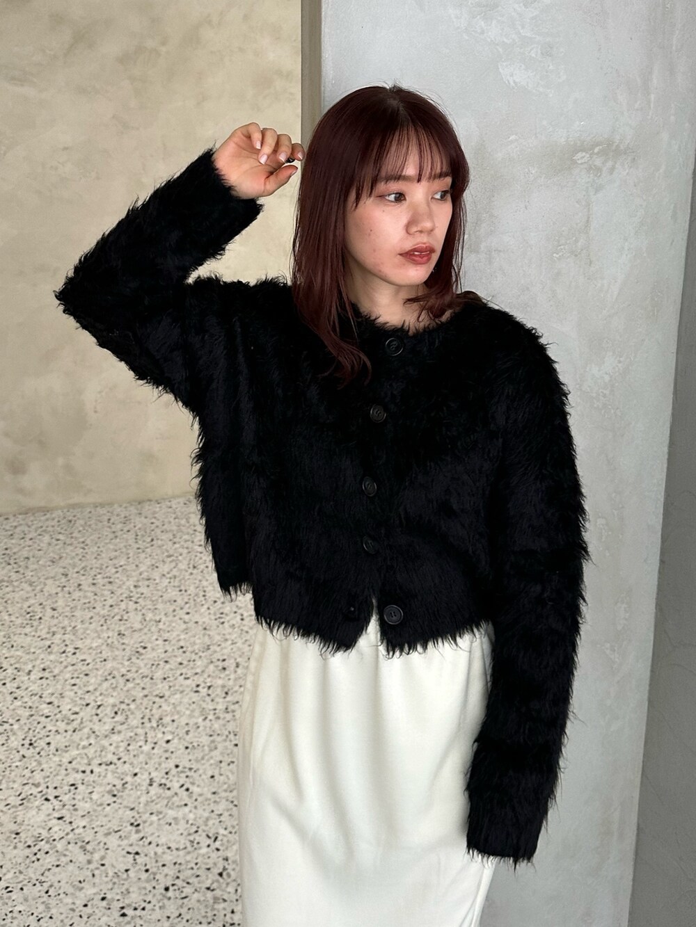 ブラック系のカーディガン/ボレロ、ホワイト系のスカート、シルバー系のショルダーバッグを着用したレディースの冬コーディネートの3枚目の写真