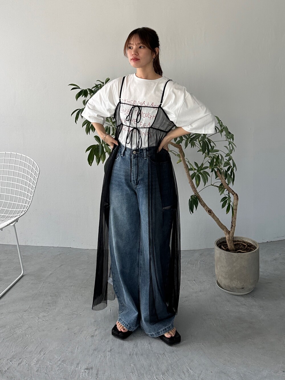 レッド系のTシャツ/カットソー、ブラック系のワンピース、ブルー系のデニムパンツを着用したレディースの夏コーディネートの2枚目の写真