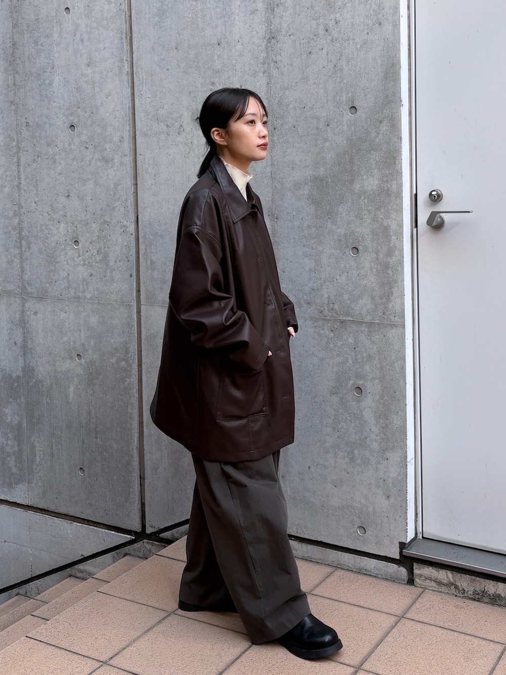 ブラウン系のカバーオール、ホワイト系のカーディガン/ボレロ、ブラック系のショルダーバッグを着用したレディースの春コーディネートの5枚目の写真