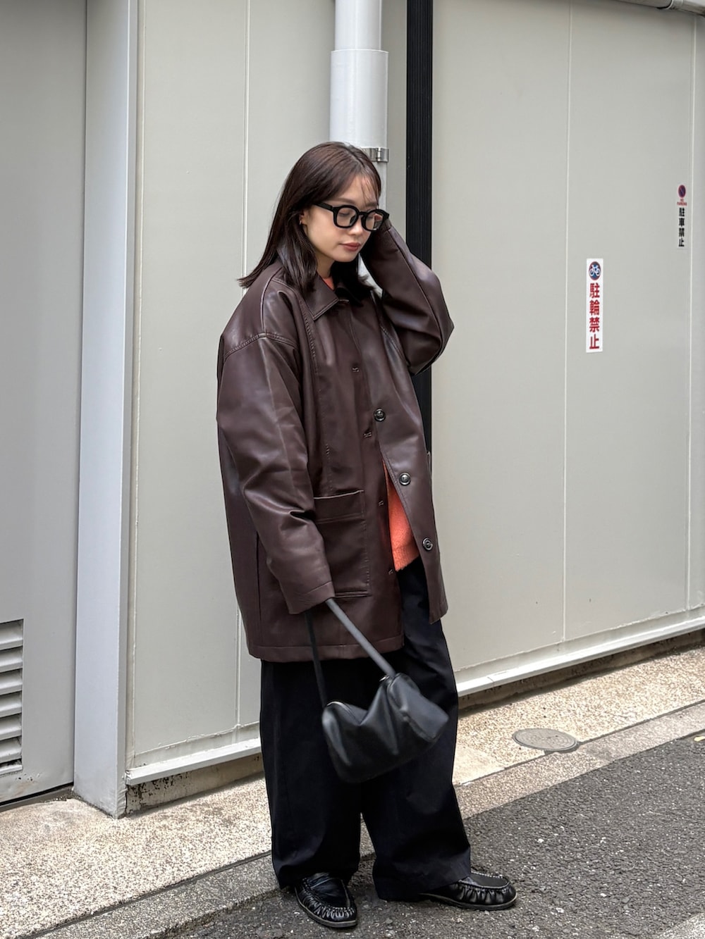 ブラウン系のカバーオール、オレンジ系のニット/セーター、ブラック系のショルダーバッグを着用したレディースの冬コーディネートの7枚目の写真