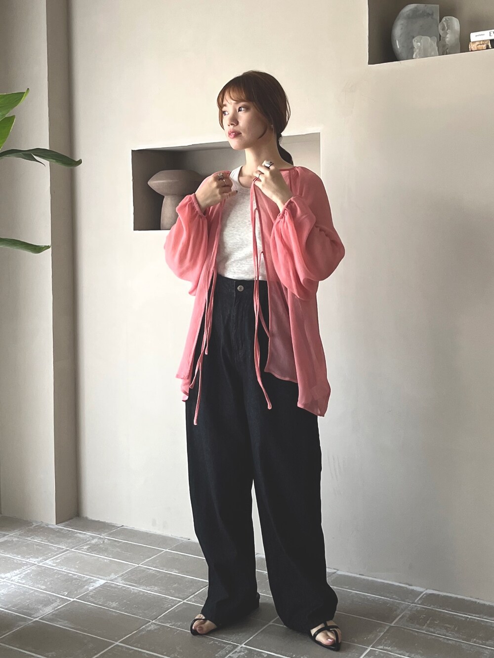 ブラック系のデニムパンツ、ブラック系のサンダル、ベージュ系のタンクトップを着用したレディースの春コーディネートの4枚目の写真