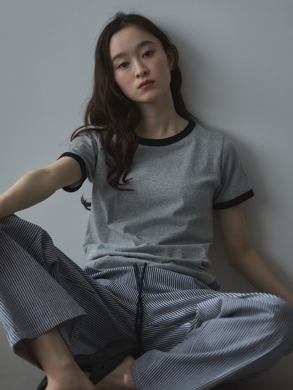 グレー系のTシャツ/カットソー、ホワイト系のデニムパンツ、ブラック系のサンダルを着用したレディースの夏コーディネートの5枚目の写真