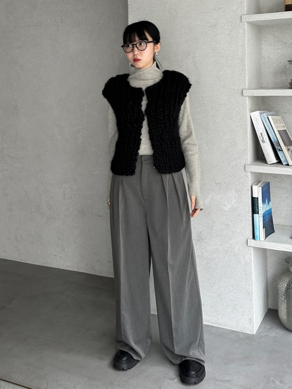 グレー系のニット/セーター、ブラック系のベスト、グレー系のスラックスを着用したレディースの冬コーディネートの4枚目の写真
