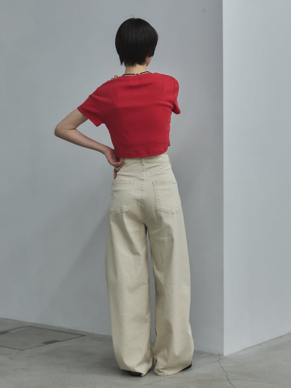 レッド系のTシャツ/カットソー、ホワイト系のデニムパンツ、ベージュ系のサンダルを着用したレディースの春コーディネートの4枚目の写真