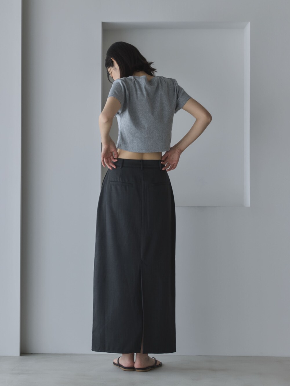 グレー系のTシャツ/カットソー、グレー系のスカート、ブラック系のサンダルを着用したレディースの夏コーディネートの3枚目の写真