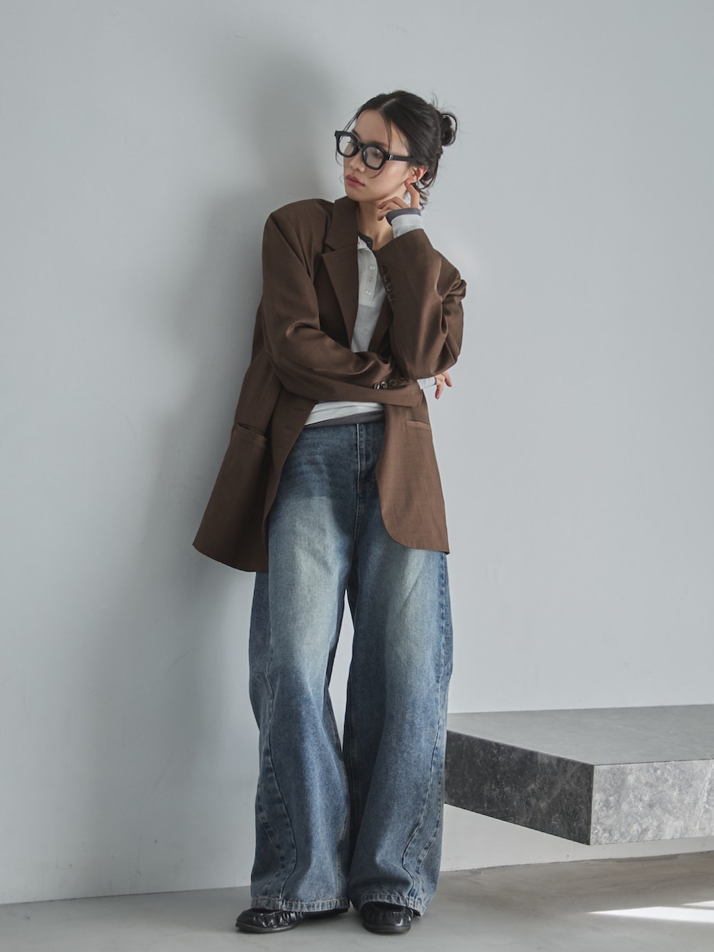 ブルー系のデニムパンツ、ブラウン系のテーラードジャケット、グレー系のTシャツ/カットソーを着用したレディースの春コーディネートの2枚目の写真