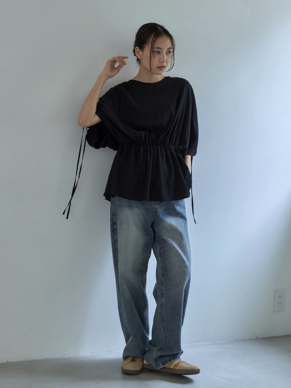 ブラック系のシャツ/ブラウス、ブルー系のデニムパンツ、ベージュ系のスニーカーを着用したレディースの夏コーディネートの3枚目の写真