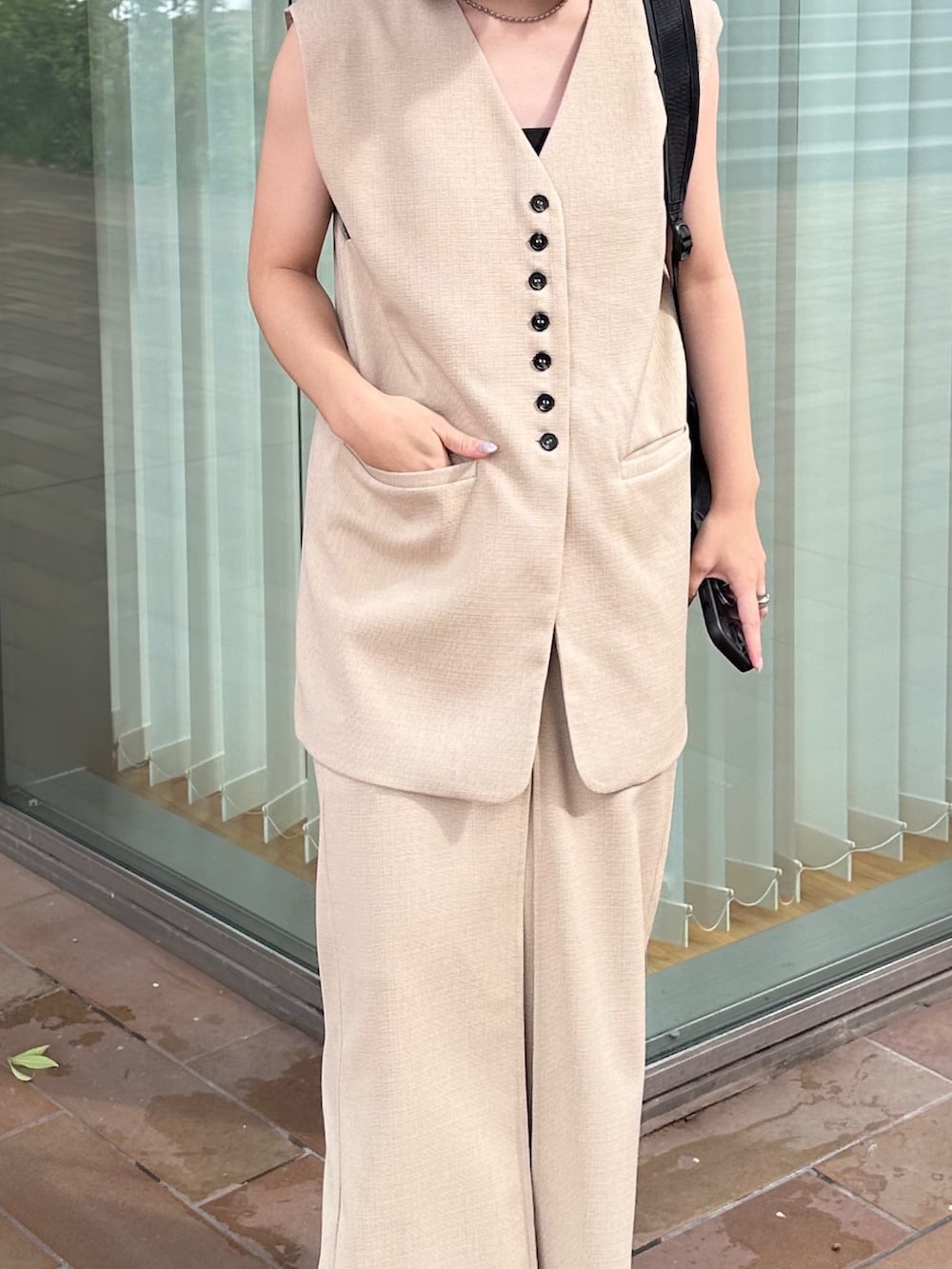 ホワイト系のベスト、ホワイト系のスカート、ブラック系のサンダルを着用したレディースの夏コーディネートの4枚目の写真