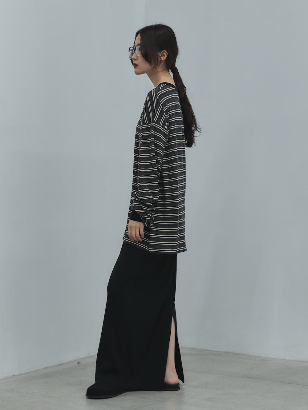 グレー系のTシャツ/カットソー、ブラック系のスカート、ブラック系のその他シューズを着用したレディースの秋コーディネートの2枚目の写真