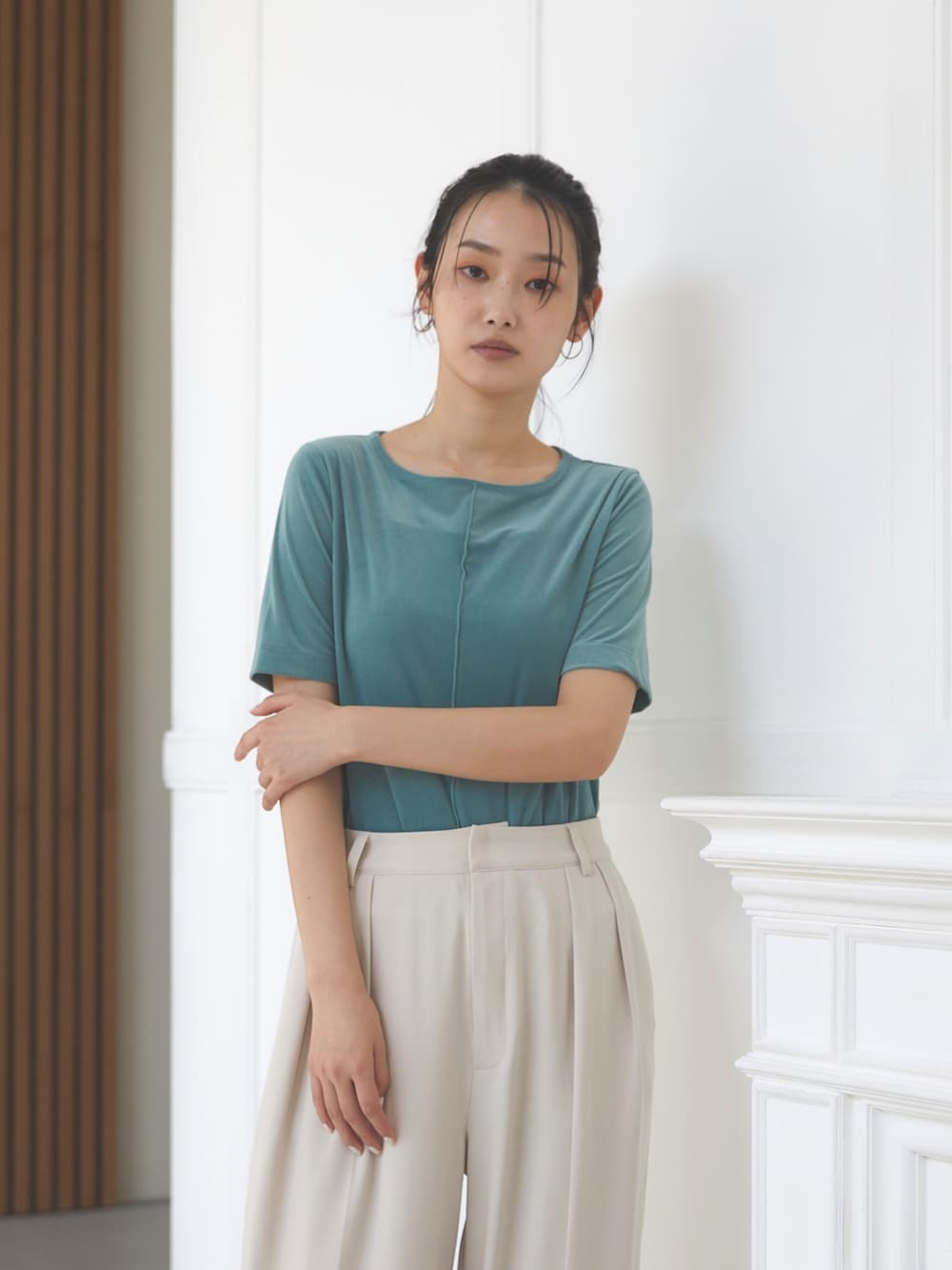 ホワイト系のスラックス、グリーン系のTシャツ/カットソー、ブラック系のスリッポンを着用したレディースの夏コーディネートの3枚目の写真