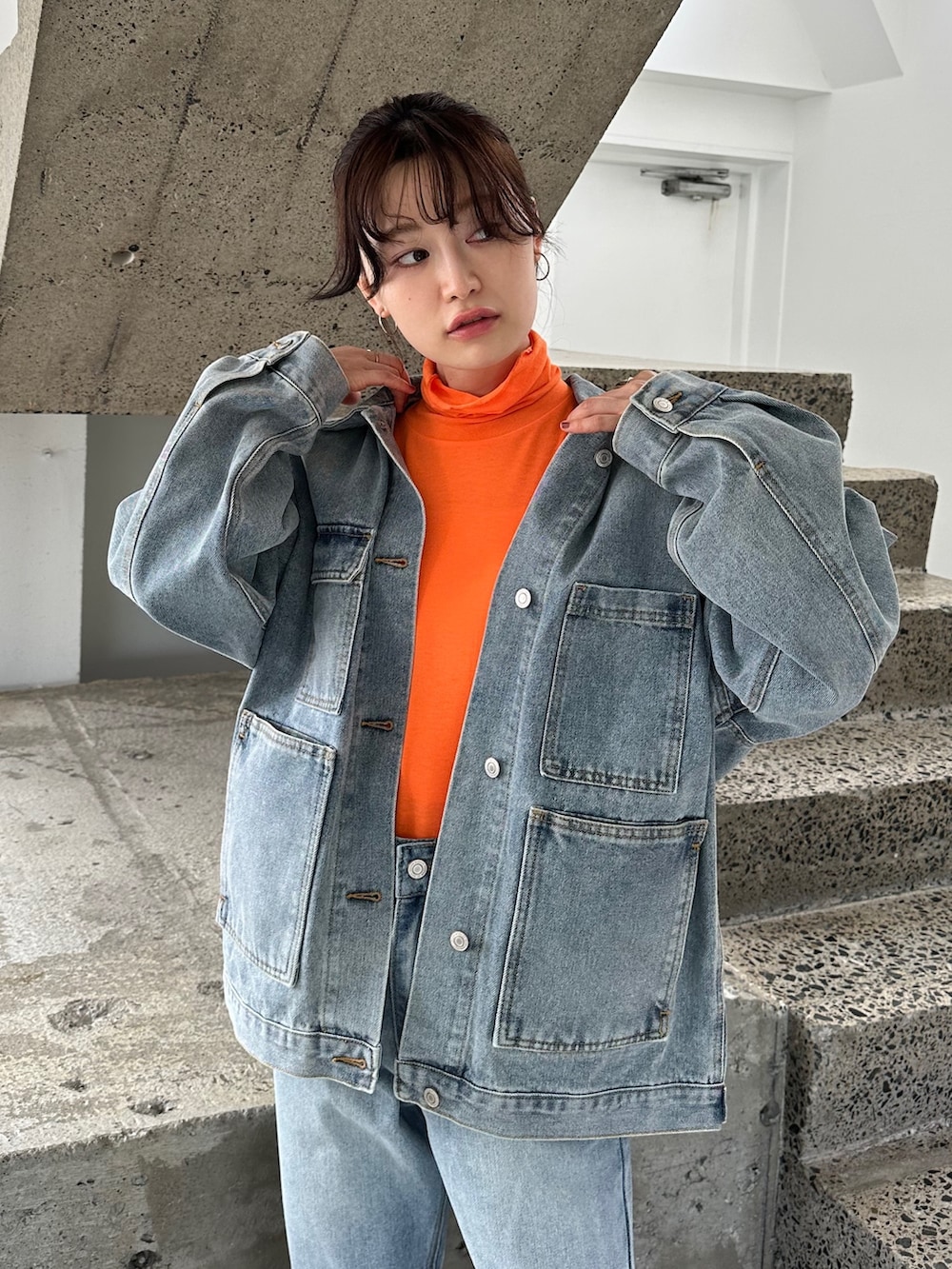 ブルー系のデニムパンツ、ブラック系のスリッポン、ブルー系のデニムジャケットを着用したレディースの秋コーディネートの3枚目の写真