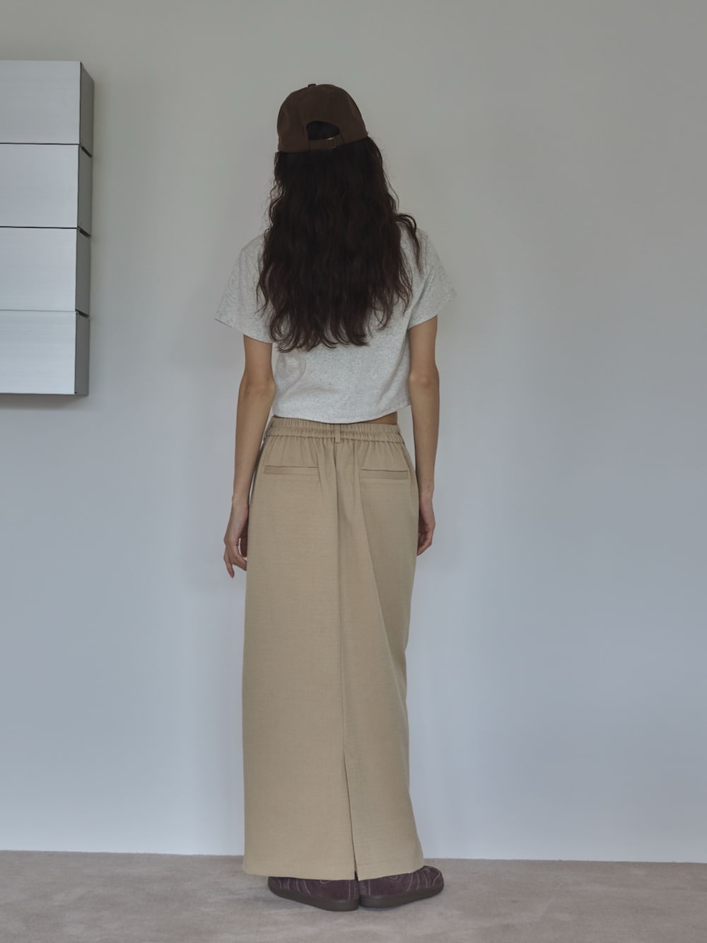 ベージュ系のTシャツ/カットソー、ホワイト系のスカート、ブラウン系のスニーカーを着用したレディースの夏コーディネートの3枚目の写真