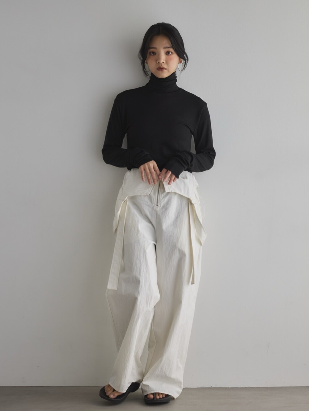 ブラック系のTシャツ/カットソー、ブラック系のサンダル、ホワイト系のサロペット/オーバーオールを着用したレディースの春コーディネートの5枚目の写真