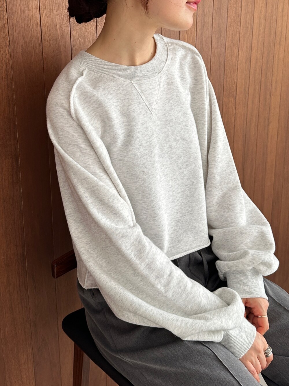 グレー系のスウェット、グレー系のスラックス、ブラック系のスニーカーを着用したレディースの秋コーディネートの3枚目の写真