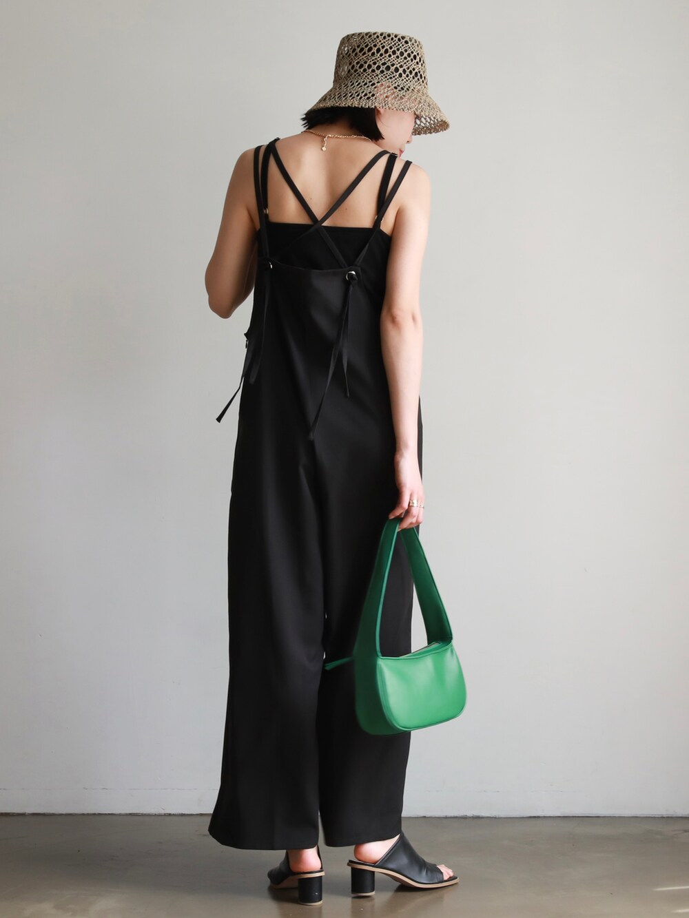 ブラック系のサロペット/オーバーオール、ブラック系のハンドバッグ、グレー系のTシャツ/カットソーを着用したレディースの夏コーディネートの4枚目の写真