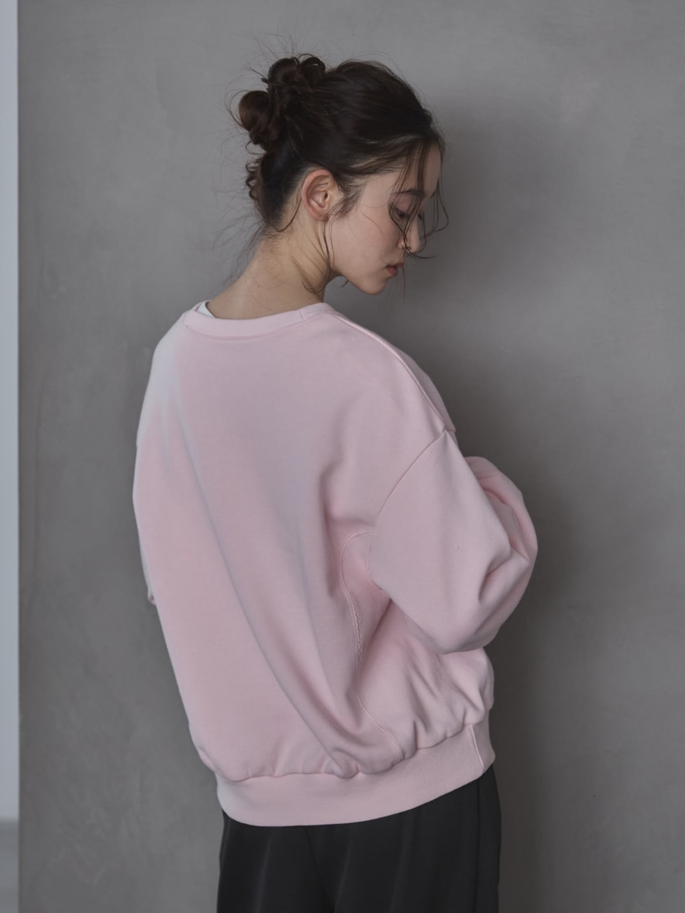 ピンク系のスウェット、グレー系のスラックス、ブラック系のその他シューズを着用したレディースの春コーディネートの5枚目の写真