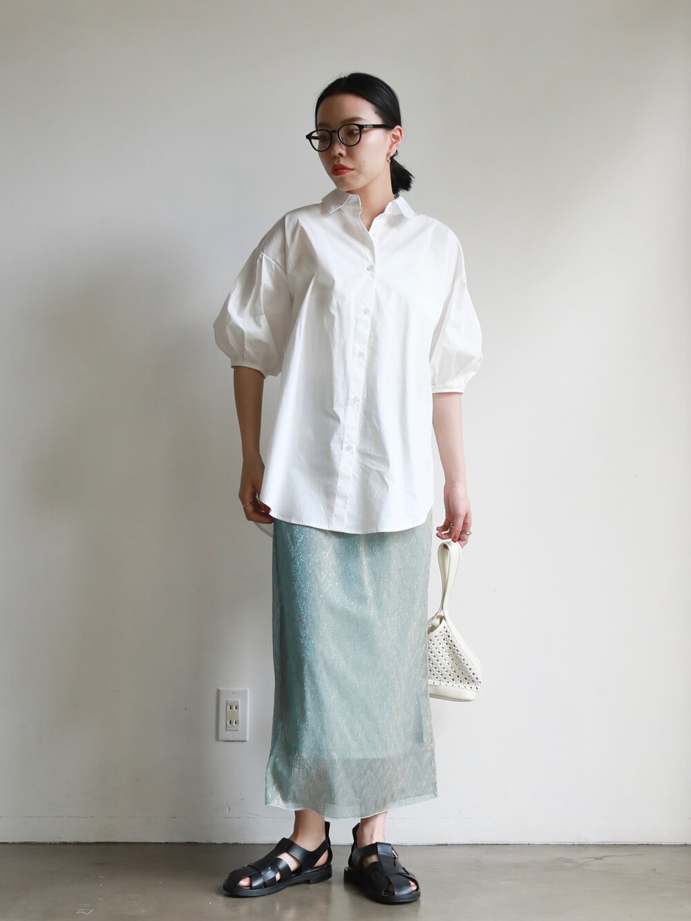 ホワイト系のトートバッグ、ブルー系のスカート、ホワイト系のシャツ/ブラウスを着用したレディースの春コーディネートの2枚目の写真