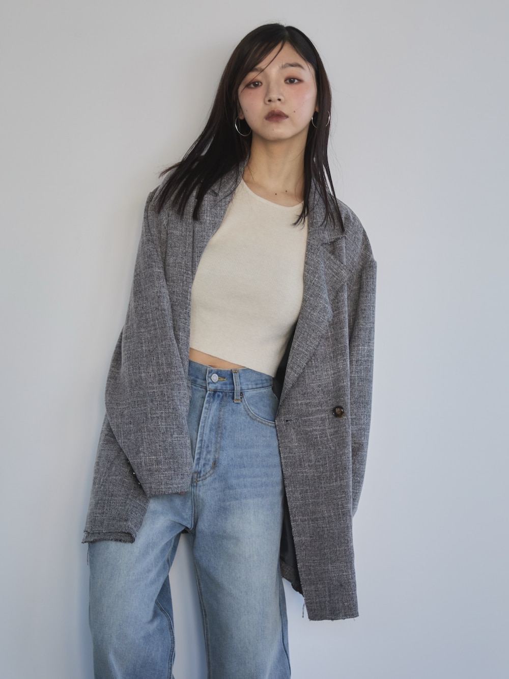 ブルー系のデニムパンツ、ブラック系のテーラードジャケット、ホワイト系のニット/セーターを着用したレディースの冬コーディネートの4枚目の写真