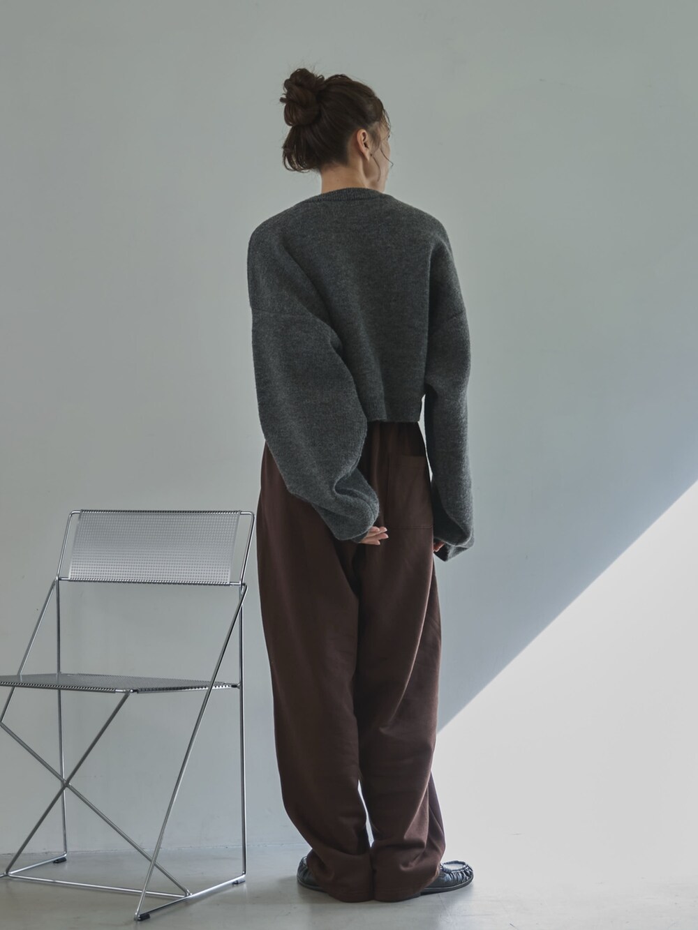 グレー系のニット/セーター、ブラウン系のその他パンツ、ブラック系のローファーを着用したレディースの冬コーディネートの4枚目の写真