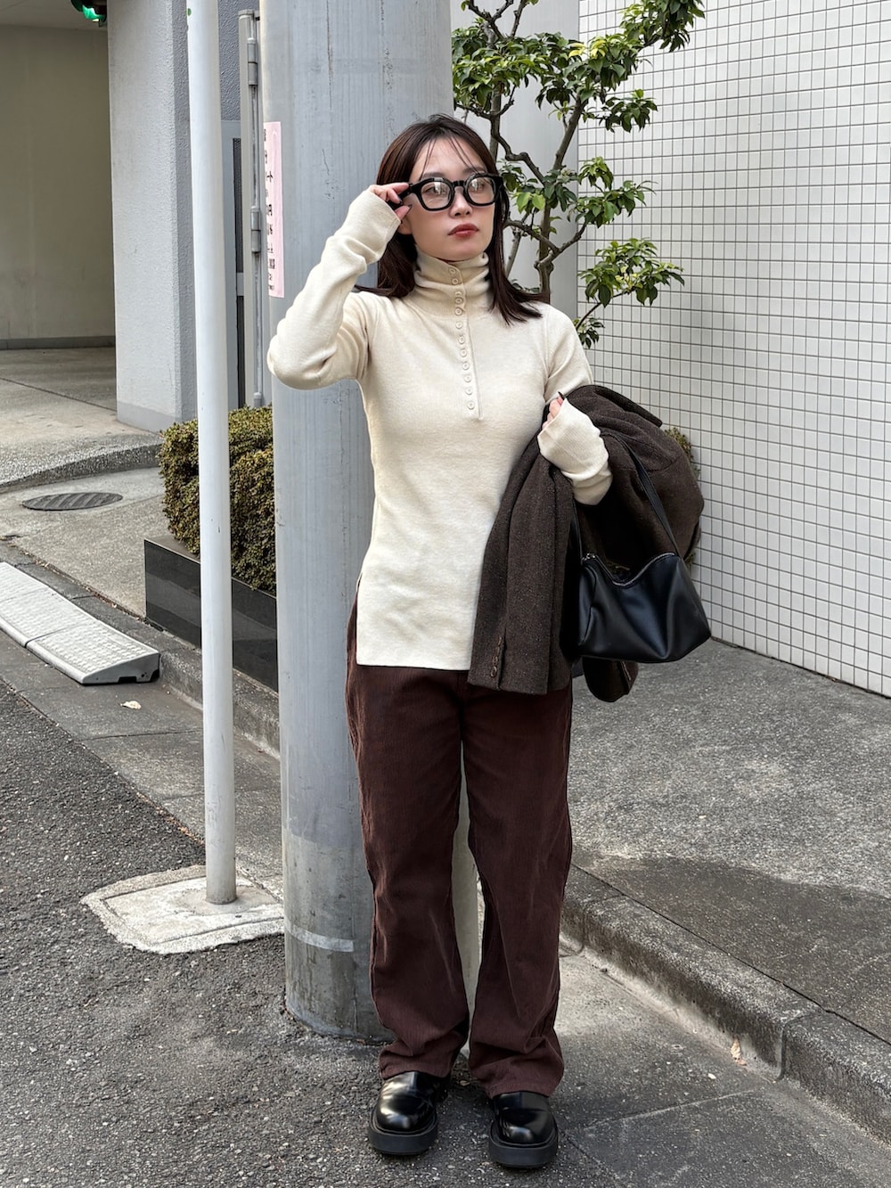 ブラウン系のテーラードジャケット、ブラック系のショルダーバッグ、ブラウン系のその他パンツを着用したレディースの冬コーディネートの4枚目の写真