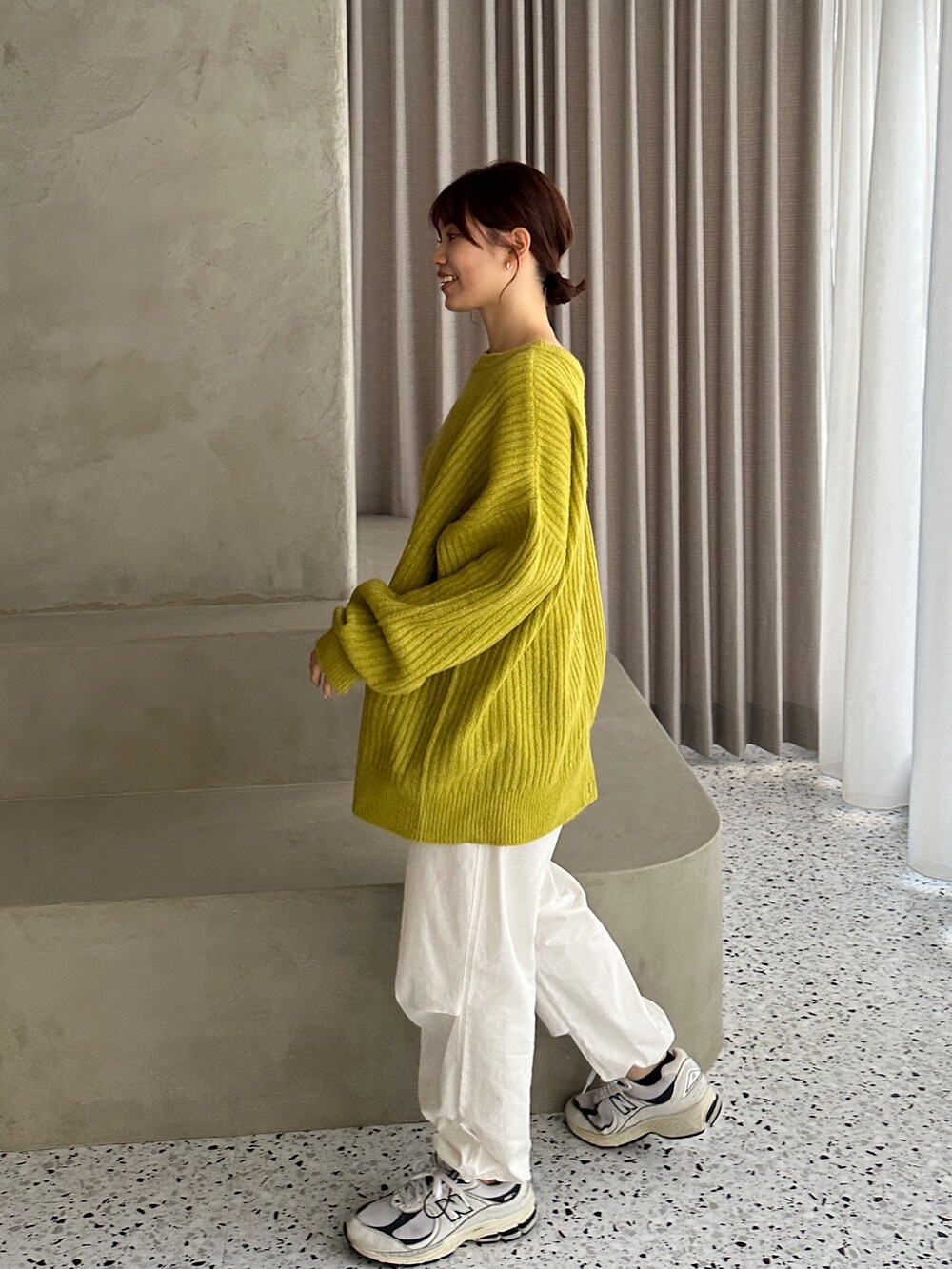 グリーン系のカーディガン/ボレロ、ホワイト系のカーゴパンツ、ホワイト系のスニーカーを着用したレディースの冬コーディネートの2枚目の写真