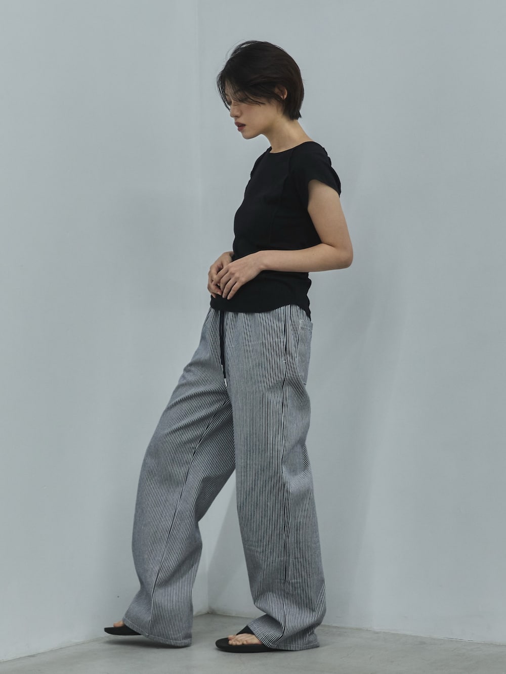 ブラック系のTシャツ/カットソー、ホワイト系のデニムパンツ、ブラック系のサンダルを着用したレディースの夏コーディネートの2枚目の写真