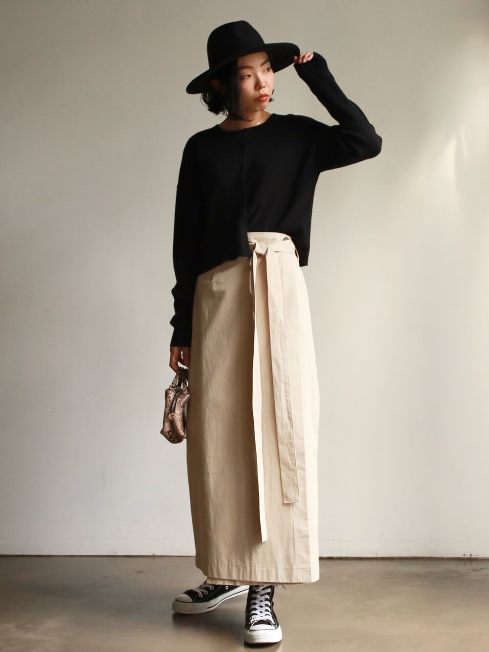 グリーン系のTシャツ/カットソー、ベージュ系のスカート、ブラック系のスニーカーを着用したレディースの冬コーディネートの4枚目の写真