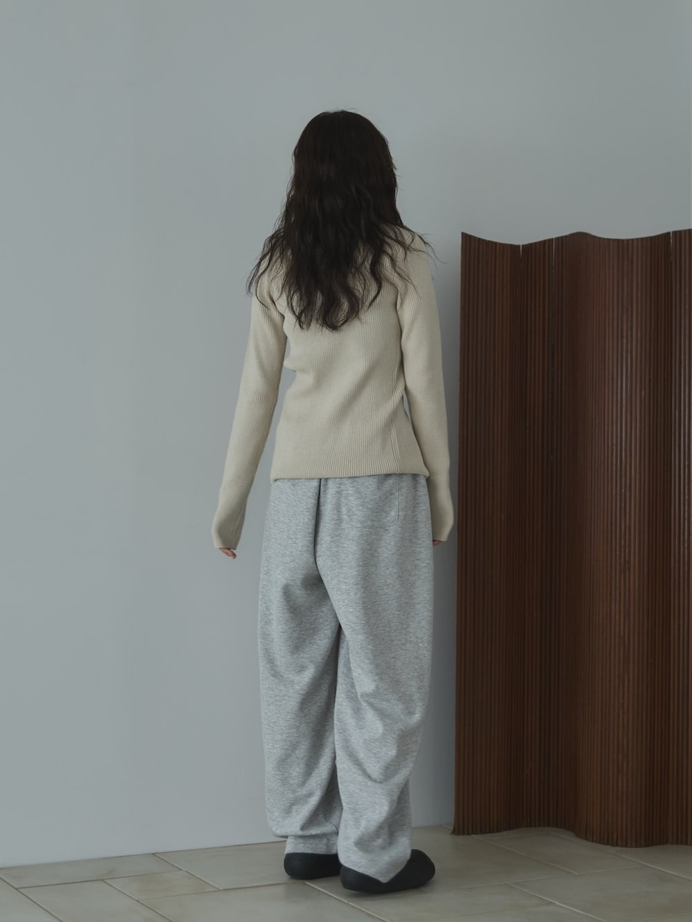 ホワイト系のカーディガン/ボレロ、グレー系のその他パンツ、ブラック系のサンダルを着用したレディースの秋コーディネートの2枚目の写真