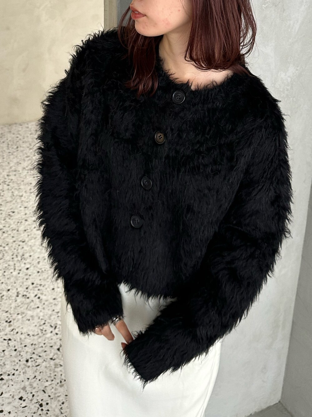 ブラック系のカーディガン/ボレロ、ホワイト系のスカート、シルバー系のショルダーバッグを着用したレディースの冬コーディネートの4枚目の写真