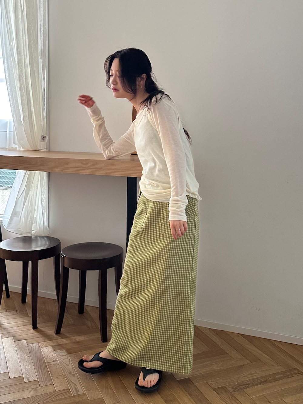 ホワイト系のTシャツ/カットソー、イエロー系のスカート、ブラック系のサンダルを着用したレディースの春コーディネートの6枚目の写真