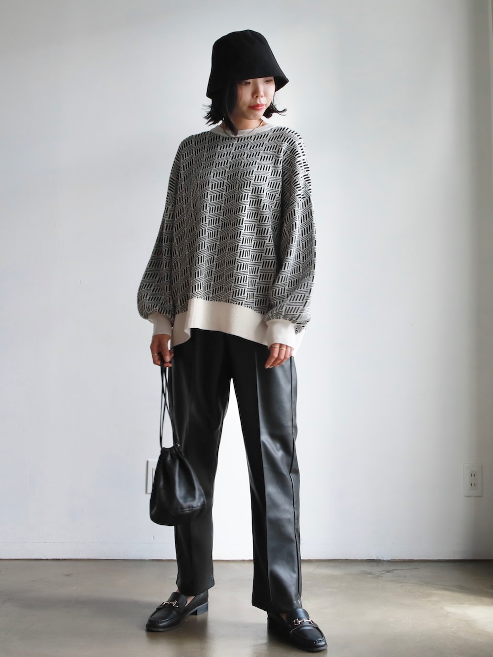 グレー系のスカート、ブルー系のTシャツ/カットソー、ブラック系のニット/セーターを着用したレディースの冬コーディネートの5枚目の写真