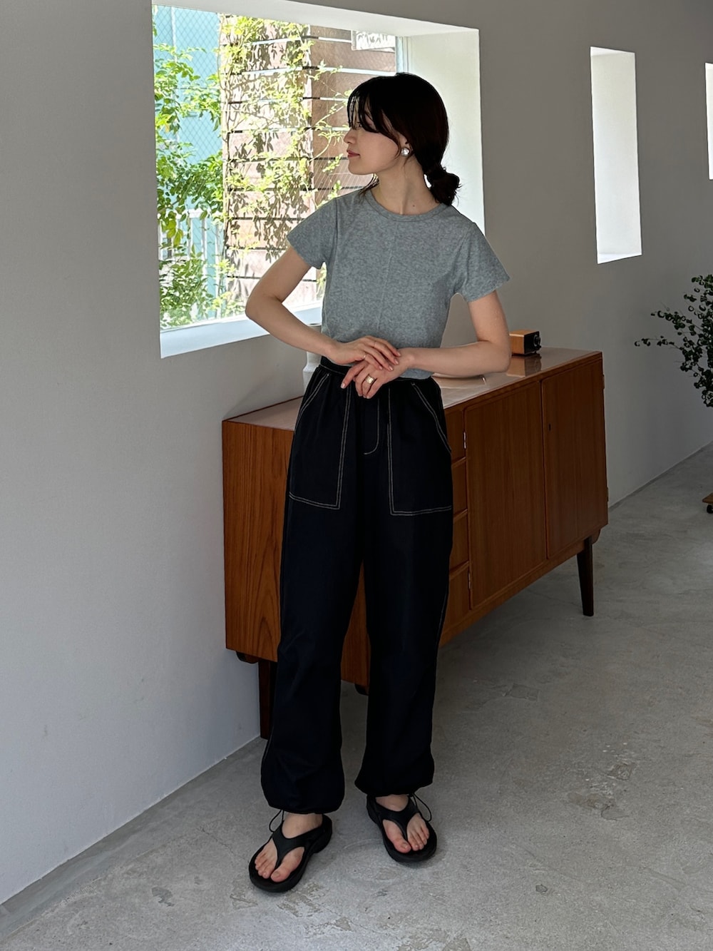 グレー系のTシャツ/カットソー、ブラック系のカーゴパンツ、ブラック系のサンダルを着用したレディースの夏コーディネートの2枚目の写真