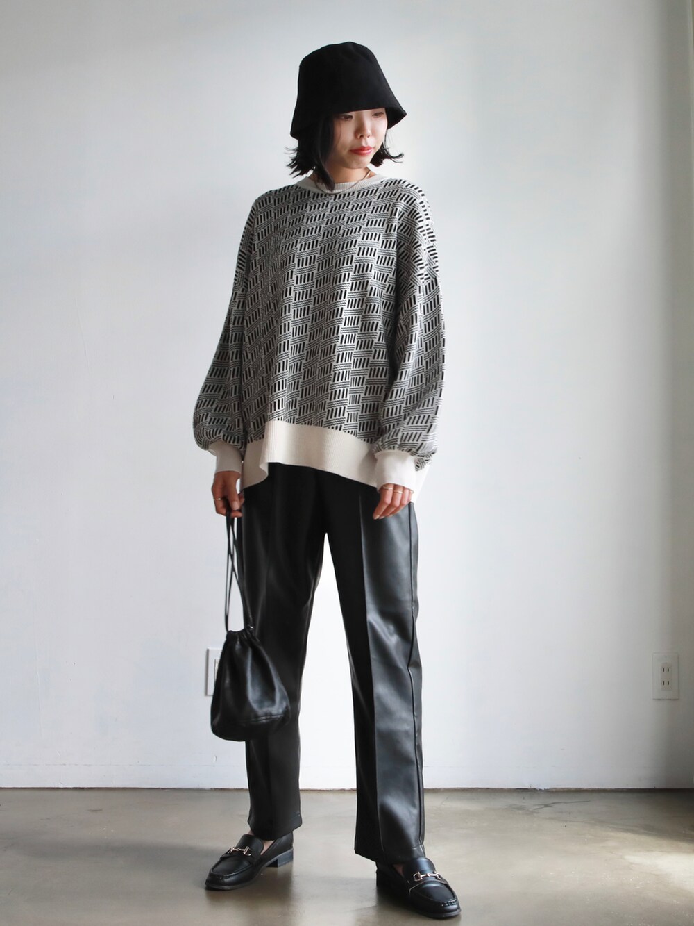 ホワイト系のトートバッグ、ブルー系のニット/セーター、ホワイト系のTシャツ/カットソーを着用したレディースの秋コーディネートの3枚目の写真