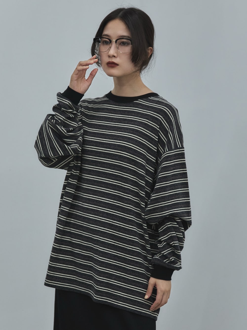 グレー系のTシャツ/カットソー、ブラック系のスカート、ブラック系のその他シューズを着用したレディースの秋コーディネートの4枚目の写真