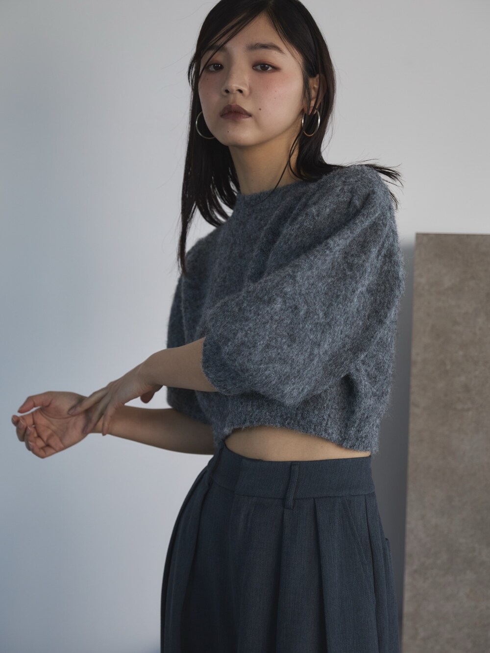 グレー系のニット/セーター、グレー系のスラックス、ブラック系のローファーを着用したレディースの冬コーディネートの5枚目の写真