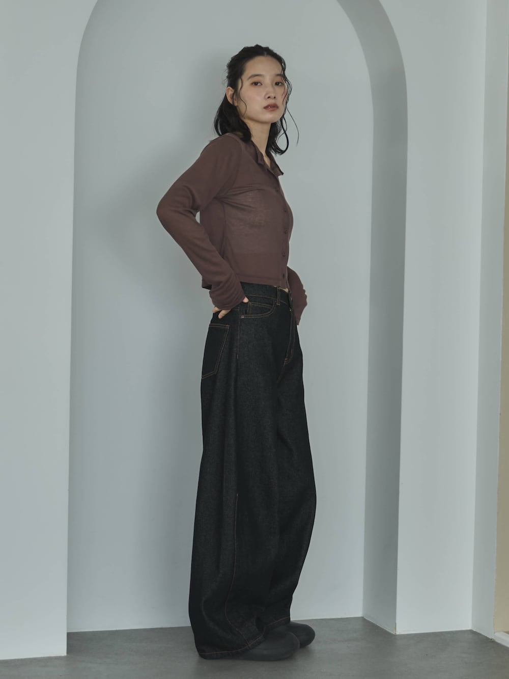 ブラウン系のカーディガン/ボレロ、ホワイト系のキャミソール、ブラック系のデニムパンツを着用したレディースの春コーディネートの2枚目の写真